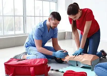 man and woman practicing cpr training and first aid emergency response on a mannequin indoors